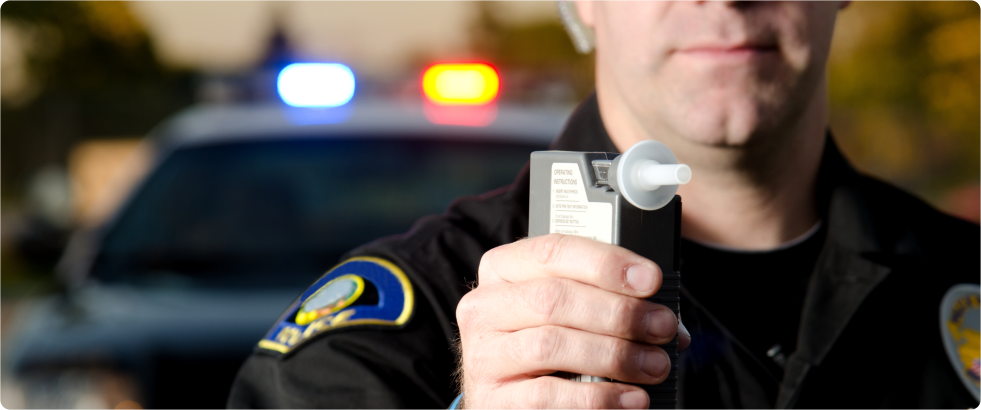 police man holding a breathalyzer